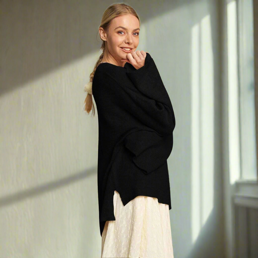 Woman wearing a black sweater over a white dress on a white background