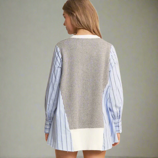 Woman wearing a layered striped shirt with a neutral patterned vest on a white background